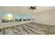 Bedroom with large windows offering ocean view, and wood-look flooring and a ceiling fan at 1214 Gulf Blvd, Englewood, FL 34223
