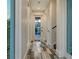 Well-lit hallway featuring luxury vinyl flooring and a glass door entrance to outdoor living space at 1214 Gulf Blvd, Englewood, FL 34223