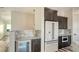 Kitchen area featuring white refrigerator, bar with beverage cooler, and marble countertops at 1214 Gulf Blvd, Englewood, FL 34223