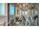 A glass enclosed shower with stone-look tile and lighted mirror at 1214 Gulf Blvd, Englewood, FL 34223