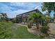 Backyard view of screened-in pool, well-manicured garden, and green foliage at 1227 Tuscany Blvd, Venice, FL 34292