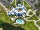 Aerial view of a clubhouse with a pool surrounded by lush landscaping and a golf course at 1227 Tuscany Blvd, Venice, FL 34292