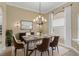 Formal dining room featuring a modern chandelier and a large window with custom curtains at 1227 Tuscany Blvd, Venice, FL 34292