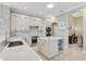 Bright kitchen featuring white cabinets, quartz countertops, modern appliances, and wine storage island at 1227 Tuscany Blvd, Venice, FL 34292
