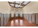 Living room with hardwood floors, coffered ceiling with fan, and decorative wood wall trim at 1227 Tuscany Blvd, Venice, FL 34292
