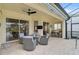 Covered patio area with comfortable seating, ceiling fan and outdoor television at 1227 Tuscany Blvd, Venice, FL 34292