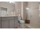Neutral bathroom showcases a double vanity, framed mirror, and glass-enclosed shower with a small stool at 14369 Eagle Branch Dr, Nokomis, FL 34275