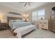 Comfortable bedroom features a ceiling fan, accent wall decor, and shuttered window at 14369 Eagle Branch Dr, Nokomis, FL 34275