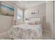 Cozy bedroom features a large window for natural light and tropical decor at 14369 Eagle Branch Dr, Nokomis, FL 34275