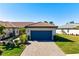 Charming home with a paver driveway, blue garage door, and lush landscaping at 14369 Eagle Branch Dr, Nokomis, FL 34275