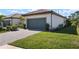 Home features a gray garage door, lush green lawn and lanscaping at 14369 Eagle Branch Dr, Nokomis, FL 34275