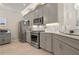 Charming kitchen features grey cabinets, stainless steel appliances, and stylish tile backsplash at 14369 Eagle Branch Dr, Nokomis, FL 34275