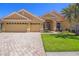 Inviting single-story home with a three-car garage, well-manicured lawn, and paver driveway at 2773 Harvest Dr, Sarasota, FL 34240
