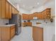 Bright kitchen features tile floors, stainless steel refrigerator, and light wood cabinets at 2773 Harvest Dr, Sarasota, FL 34240