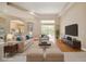 Spacious living room featuring a tray ceiling, large windows, and stylish neutral-toned furniture at 2773 Harvest Dr, Sarasota, FL 34240