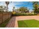 Backyard patio area with brick pavers, green turf, and a wooden privacy fence at 2826 Marlette St, Sarasota, FL 34231