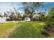 Expansive backyard featuring lush green grass, a sparkling pool, and mature trees providing ample shade at 2826 Marlette St, Sarasota, FL 34231