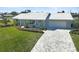 Charming single-story home featuring a well-manicured lawn, white tile roof, and a spacious driveway leading to an attached garage at 308 Matisse E Cir, Nokomis, FL 34275