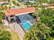 Aerial view of a home with a screened-in pool and spacious backyard surrounded by tropical vegetation and a privacy fence at 424 Cezanne Dr, Osprey, FL 34229