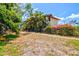 The fenced backyard features tropical plants, a patio, and an outdoor living area with mature trees for shade at 424 Cezanne Dr, Osprey, FL 34229