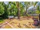 The backyard features a fenced area with mature trees and a small seating area, creating a peaceful and private retreat at 424 Cezanne Dr, Osprey, FL 34229