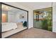 Bedroom view showcasing sliding door to screened balcony overlooking lush, tropical foliage at 424 Cezanne Dr, Osprey, FL 34229
