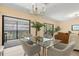 Open dining area flowing to the living room features a glass table and a view to a screened patio at 424 Cezanne Dr, Osprey, FL 34229