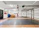 Spacious two car garage featuring epoxy flooring, a seating area, overhead storage, and a garage door opener at 424 Cezanne Dr, Osprey, FL 34229