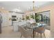 Bright kitchen with a dining area features white cabinetry, modern appliances, and views of the enclosed patio at 424 Cezanne Dr, Osprey, FL 34229