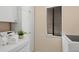 Bright laundry room with washer, dryer, storage cabinets, and natural light at 424 Cezanne Dr, Osprey, FL 34229