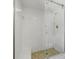 White tiled shower with glass door, bench, and shower caddy at 424 Cezanne Dr, Osprey, FL 34229