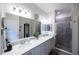 Clean bathroom with double sinks, a large mirror, and a tiled shower at 6614 162Nd E Pl, Parrish, FL 34219