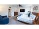 Large bedroom with a TV, blue couch, nightstand, and dresser at 6614 162Nd E Pl, Parrish, FL 34219