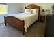 Well-lit bedroom with carpet floors, ceiling fan and a classic wooden bed at 6614 162Nd E Pl, Parrish, FL 34219