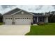 Charming single-Gathering home features a three-car garage, manicured lawn and welcoming curb appeal at 6614 162Nd E Pl, Parrish, FL 34219