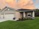 Charming single-story home featuring a two-car garage, manicured lawn, and colorful flower beds at 6614 162Nd E Pl, Parrish, FL 34219