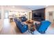 Open-concept living room featuring hardwood floors, a sleek entertainment center, and a modern kitchen view at 6614 162Nd E Pl, Parrish, FL 34219