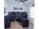 Well-lit office with a large desk, comfortable chairs, and organized shelving, creating a functional workspace at 6614 162Nd E Pl, Parrish, FL 34219