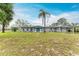 Charming single-story home featuring a spacious front yard, complemented by lush greenery and a welcoming teal-colored front door at 800 Riviera St, Venice, FL 34285