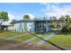Charming single-story home featuring a carport, blue exterior, and well-maintained front yard at 8466 Maureen Ave, North Port, FL 34287