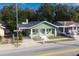Aerial view of a well-maintained home with a charming front porch and lush landscaping at 1010 E Lake Ave, Tampa, FL 33605