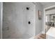 Updated bathroom features a walk-in shower with marble-look tile surround and black and white tiled floor at 1010 E Lake Ave, Tampa, FL 33605