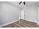 This bedroom features a ceiling fan, neutral walls, wood-look flooring, and access to another room at 1010 E Lake Ave, Tampa, FL 33605