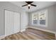This bedroom features a ceiling fan, neutral walls, double door closet, wood-look flooring, and a window at 1010 E Lake Ave, Tampa, FL 33605