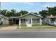 Quaint green home with a charming front porch, white pillars, and well-kept landscaping at 1010 E Lake Ave, Tampa, FL 33605