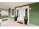Inviting front door with side windows, potted plants, and 'hello' mat on the covered porch at 1010 E Lake Ave, Tampa, FL 33605