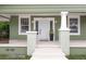 Charming front porch with white pillars, fresh paint, and stylish potted plants at 1010 E Lake Ave, Tampa, FL 33605