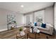 Living room features neutral color palette, front door access, natural light, and wood-look flooring at 1010 E Lake Ave, Tampa, FL 33605