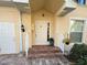 Charming front entrance with brick steps, a white door, and colorful flower pots, creating a welcoming ambiance at 1274 Burgos Dr # 1101, Sarasota, FL 34238