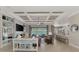 Spacious living room with coffered ceilings, shelving, and an open floor plan to the kitchen at 20686 Valprato Ct, Venice, FL 34293